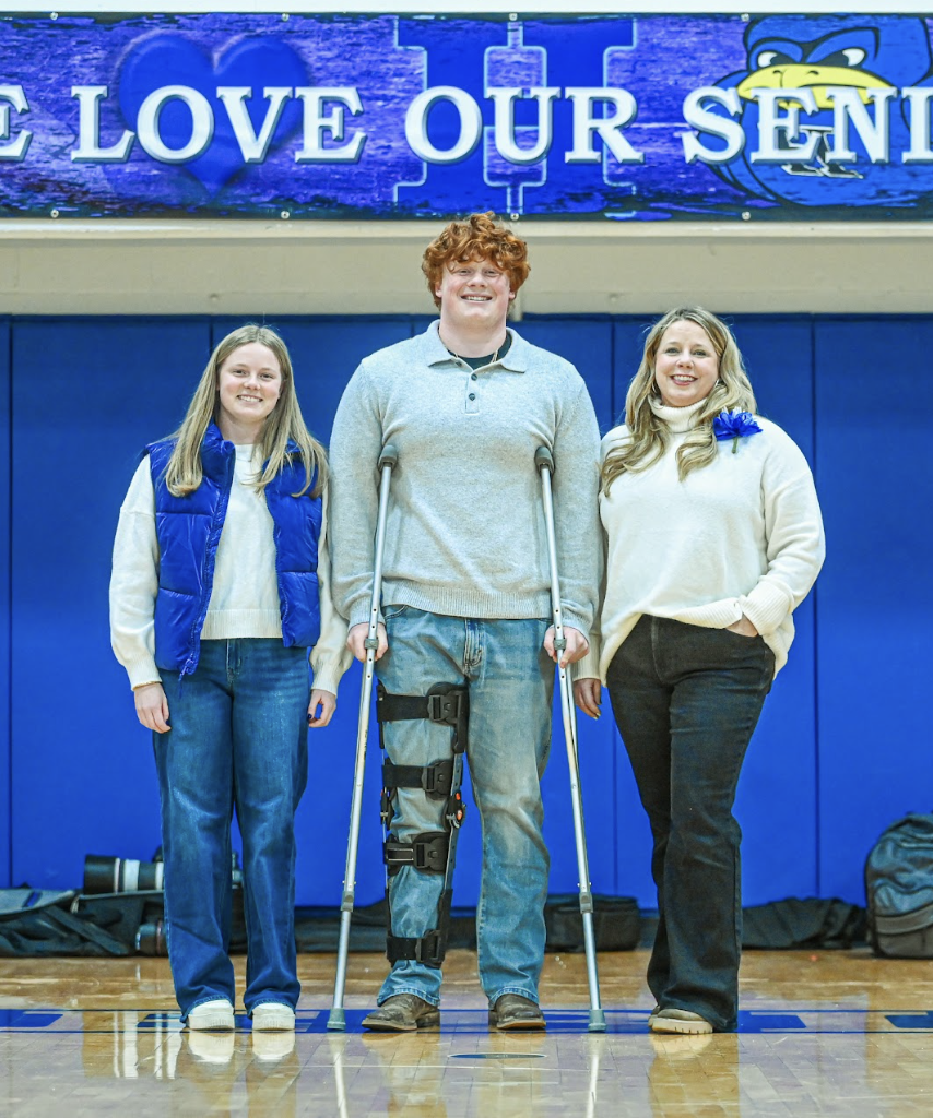 Torin Bryant (12) stands next to his sister and mother for his swim senior night photos. 